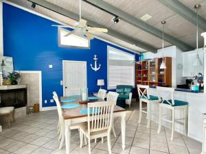 une salle à manger avec un mur bleu, une table et des chaises dans l'établissement Ocean View Beach House Historic Downtown 10 mins, à Saint Augustine