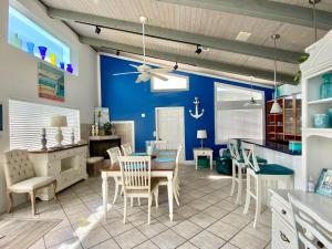 une salle à manger avec des murs bleus, une table et des chaises dans l'établissement Ocean View Beach House Historic Downtown 10 mins, à Saint Augustine
