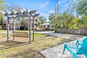 a playground with a blue bench in a yard at Cute Downtown Cottage with Large Yard and BBQ plus Smart TVs in Saint Augustine