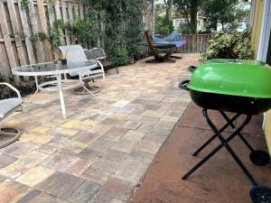 a grill on a patio with a table and chairs at Comfy and Quiet APT 5 min Walk to Historic Downtown in St. Augustine