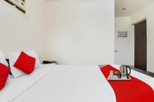 a bedroom with a white bed with red pillows at OYO The Safe Hotels in Cochin