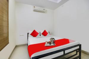 a bed in a room with red pillows on it at OYO The Safe Hotels in Cochin