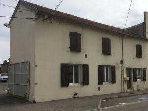 Gîte Lunéville, 4 pièces, 5 personnes - FR-1-584-106 في لونفيل: مبنى أبيض بنوافذ مغلقة بنية على شارع