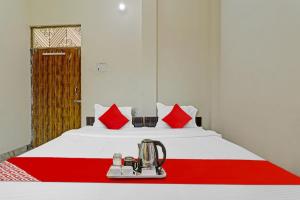 a room with a bed with a red and white blanket at Flagship Pratap Guest House in Sultānpur
