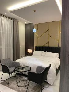 een slaapkamer met een bed en 2 stoelen en een tafel bij سيلينا هاوس الفندقية in Jeddah