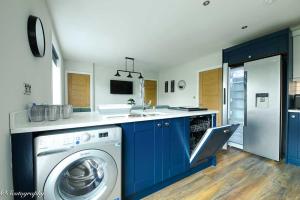a kitchen with blue cabinets and a washing machine at Bay View Holiday Apartments in Scarborough