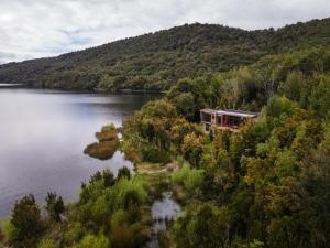 una casa al lado de un lago con una montaña en Casas Martín Pescador, Lago Huillinco, Chiloe, en Chonchi