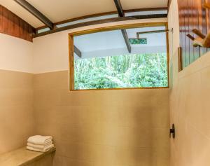 a bathroom with a window and a shower at Encanta La Vida in Cabo Matapalo