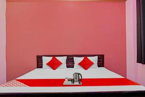 una camera da letto con un letto con cuscini rossi di SPOT ON Hotel Kanha Inn a Chaukhandi