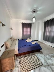 a bedroom with a large bed with a blue blanket at Auberge Ksar Ait Ben Haddou in Aït Ben Haddou