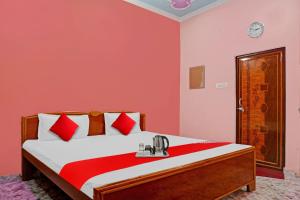 1 dormitorio con 1 cama con paredes rojas en SPOT ON Hotel Kanha Inn en Chaukhandi