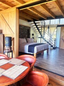 a bedroom with a bed and a table and chairs at Hípico Diamante in Tapalpa