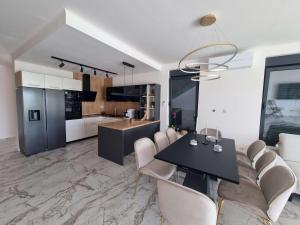 a kitchen and dining room with a black table and chairs at Holiday house with a swimming pool Banjol, Rab - 22703 in Rab