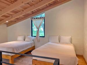 two beds in a room with a window at Hípico Diamante in Tapalpa