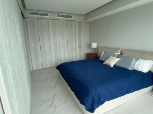 een slaapkamer met een blauw bed in een witte kamer bij NEW Nautico with Marina View and Rooftop Pool plus Gym in Puerto Vallarta