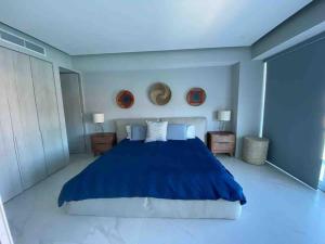 a bedroom with a blue bed and two night stands at NEW Nautico with Marina View and Rooftop Pool plus Gym in Puerto Vallarta