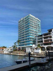 a tall building next to a body of water at NEW Nautico with Marina View and Rooftop Pool plus Gym in Puerto Vallarta