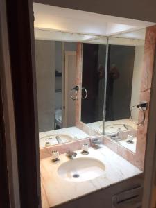 - un miroir de salle de bains avec lavabo et une personne prenant une photo dans l'établissement NEW Marina Vallarta Loft Pool BBQ Beach 5 mins, à Puerto Vallarta