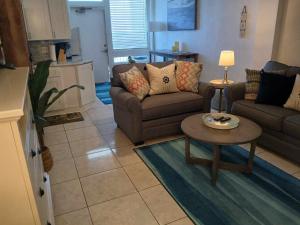 een woonkamer met een bank en een tafel bij Direct ocean front view 1 bedroom working pool in Daytona Beach