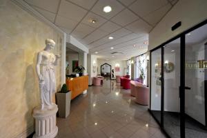 a statue of a woman on a pedestal in a lobby at Tuscia Hotel in Viterbo