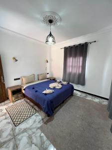 a bedroom with a blue bed and a window at Auberge Ksar Ait Ben Haddou in Aït Benhaddou