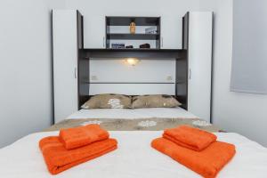 a bed with two orange towels on top of it at Apartments with a parking space Mastrinka, Ciovo - 22976 in Trogir