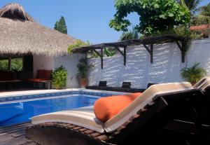 ośrodek z basenem z dachem krytym strzechą w obiekcie La Casa Bonita w mieście Puerto Escondido