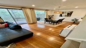 a living room with a black couch and a table at Villa 2br Riesling Villa located within Cypress Lakes Resort in Pokolbin