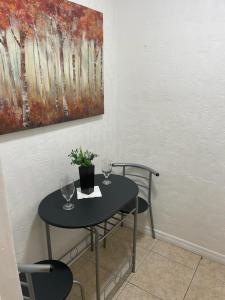 una mesa con dos copas de vino y una pintura en Hostal Sky Crest en Clearwater