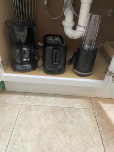 een plank met een koffiezetapparaat en een blender bij Hostal Sky Crest in Clearwater