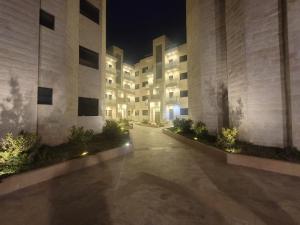 an empty courtyard of an apartment building at night at Gardens Company in Amman