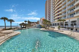 a large swimming pool next to a large building at Ocean Walk Condominiums in Daytona Beach