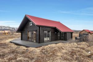 une petite maison avec un toit rouge dans un champ dans l'établissement Spacious 4-Bedroom Home in Southern Iceland, à Selfoss