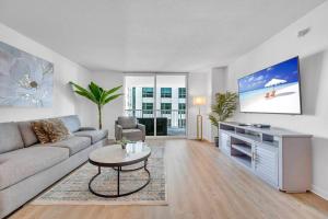 un soggiorno con divano e TV di Stunning 1 BDR 1 BTH • Brickell • Bay & City Views a Miami