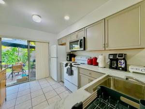 a kitchen with white appliances and a view of a patio at Seaside Elegance 3 Mi to FM Beach Paradise Sleep 6 in Fort Myers Beach