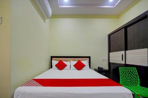 a bedroom with a large bed with red pillows at Flagship Hotel Pvs Grand in Vijayawāda