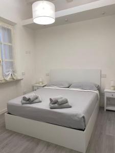 a white bedroom with a bed with towels on it at II Sogno nel Vicolo in Pisa