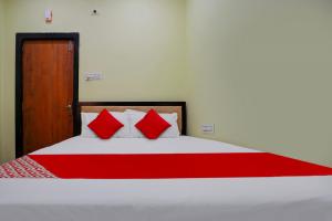 a bedroom with a large bed with red pillows at Flagship Hotel Pvs Grand in Vijayawāda