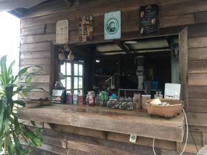 a counter in a wooden building with food on it at สวนบ้านนอก SuanBaanNoak in Ban Phaet