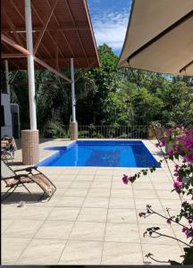 a swimming pool with a chair and an umbrella at 1 Large beautiful poolside condo with AC! Great Location! in Carrillo