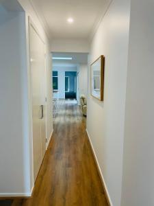 a hallway with white walls and wooden floors at Brand New House in Lakes Entrance in Lakes Entrance
