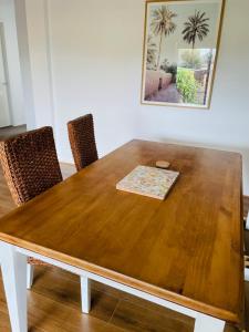 a dining room table with chairs and a wooden table at Brand New House in Lakes Entrance in Lakes Entrance