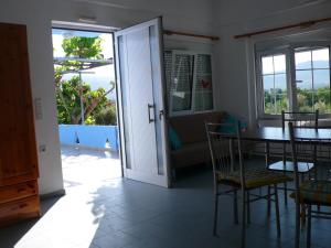 a dining room with a table and chairs and a door at Stefanos Garden in Arménoi