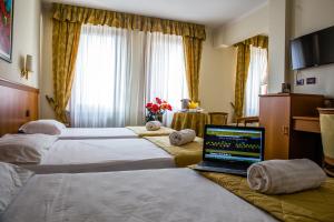 una camera d'albergo con due letti e un computer portatile di Hotel Galant a Venaria Reale