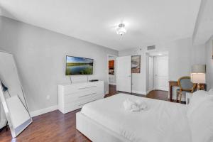 Beautiful 1 BED 1 BTH • Brickell في ميامي: غرفة نوم بيضاء مع سرير أبيض وتلفزيون