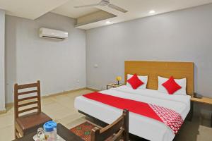 um quarto com uma cama grande e almofadas vermelhas em OYO Flagship Red Stay Near V3S Mall em Nova Deli