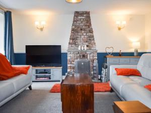 a living room with a couch and a fireplace at Sycamore Cottage in Broomhill