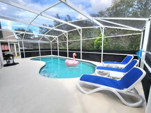een zwembad met twee stoelen en een zwaan in een tent bij Home Close to Disney Parks/Amazing Private Pool in Orlando