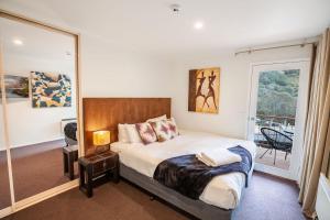 a bedroom with a bed and a large mirror at Lhotsky Apartments in Thredbo