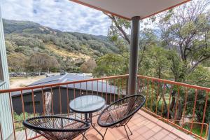 a balcony with two chairs and a table at Lhotsky Apartments in Thredbo